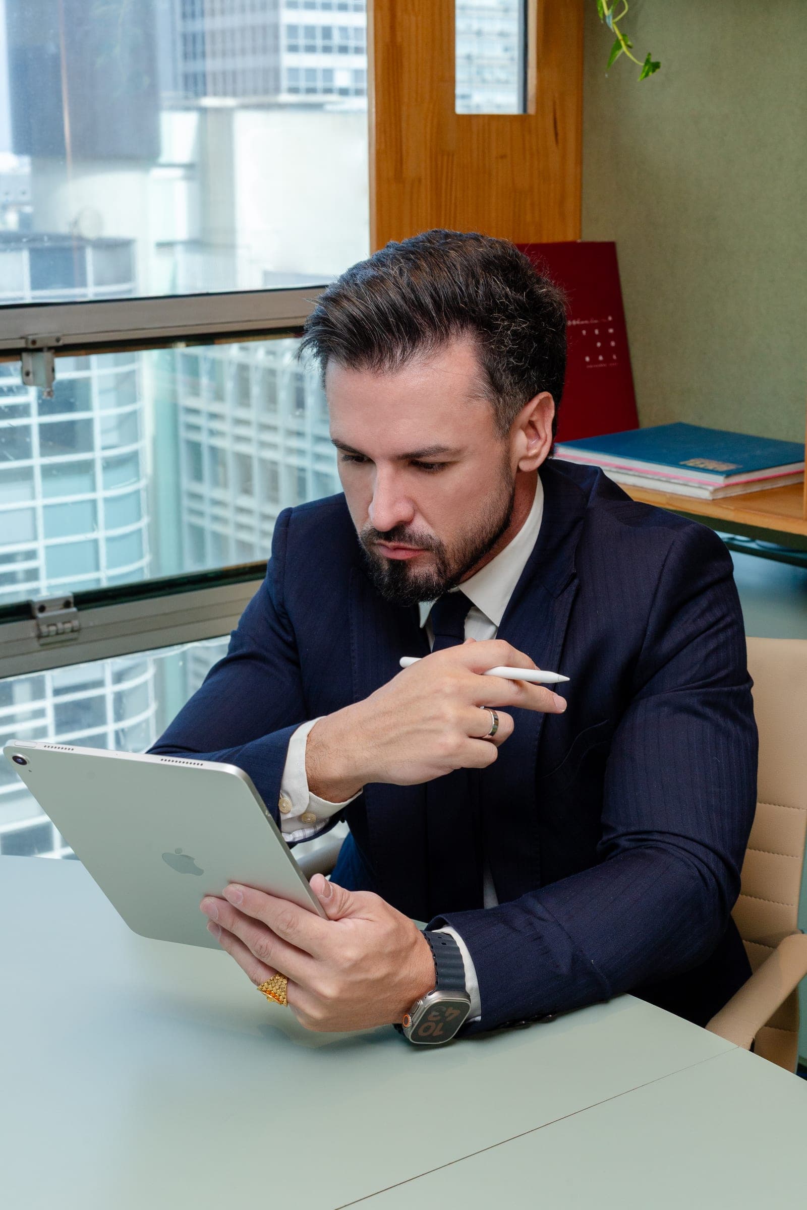 Vinicius Del Rio analisando um documento no iPad, no escritório